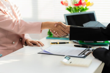 Real estate agents and clients shake hands and celebrate the successful completion of a contract...