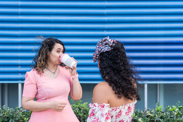 Women friends talking and drinking coffee outdoors