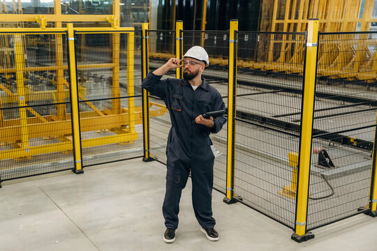 Holding digital tablet. Warehouse worker in an industrial environment of a factory or storage area