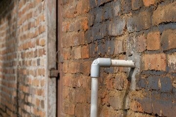 PVC pipe that goes into a brick wall. For graphic design, 3D rendering and banners