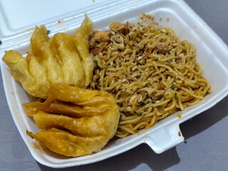 Mie Gacoan, Fried Noodles with Spicy Levels, is very popular in Indonesia, served with Fried Dumplings, sprinkled with chicken and other toppings, has a spicy taste and delights its fans.	