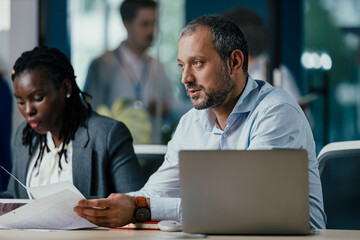 Senior Management Team Leading New Employee Feedback Session in Modern Open Plan Office