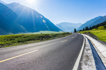 Asphalt road and green grass with beautiful mountain nature landscape in summer