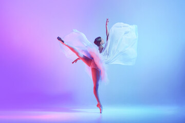 Ballet dancer in expansive high kick with flowing fabric on neon blue-violet stage. Concept of futuristic visuals, motion-led creativity, expressive performance design.