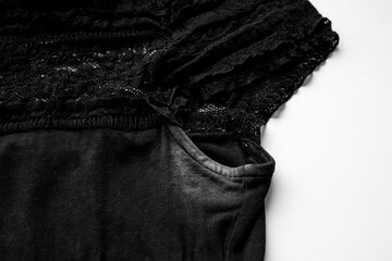 Ugly white antiperspirant stick armpit stains on a woman`s black T-shirt.