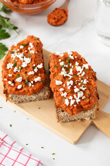Homemade ajvar dip on bread slices with cheese and parsley. Traditional Macedonian food concept.