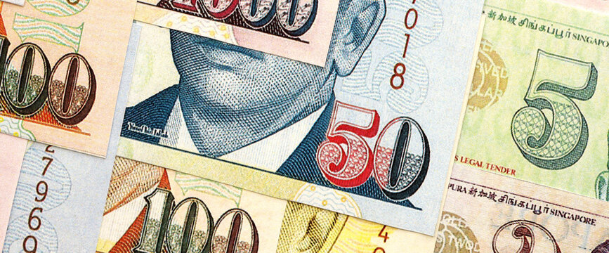 Singapore Dollar currency money bills. SGD currency banknotes in pile with different denomination close up