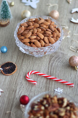 Various Christmas decorations, cookies, chocolate and nuts on wooden background. Selective focus.
