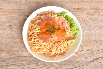 spicy stir fried spaghetti with slice ham pork dressing Rose Korean sauce topping shrimp egg on plate 