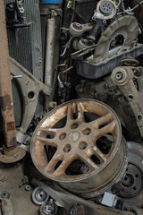 Pile of Old Rusty Scrap Metal Auto Parts in Workshop Corner. Used Car Components, Including Wheel Rim Radiators and Mechanical Parts for Recycling, Salvage Junkyard or Automotive Repair