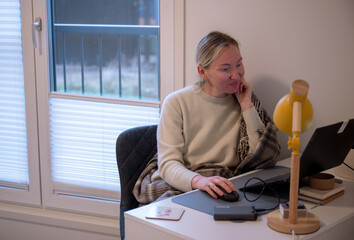 Woman working on laptop at home office desk