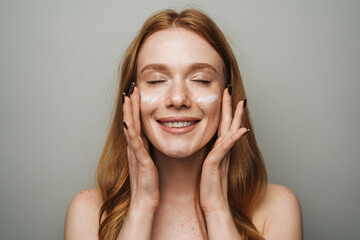 Obraz premium Sedate Portrait Of Woman Gently Massaging Face With Soft Light Illuminating Her Skincare Process