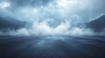 Empty asphalt road with misty white smoke and cloudy sky over mountain landscape creating mysterious and calm atmosphere in early morning
