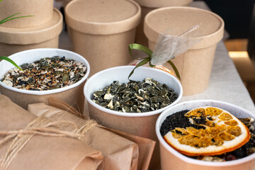 Various types of tea leaves are on display at the farmers' market, and samples of dried and cut tea are on display at the counter.