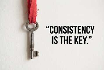 Motivational quote consistency is the key with golden key and red ribbon, success discipline habit concept.