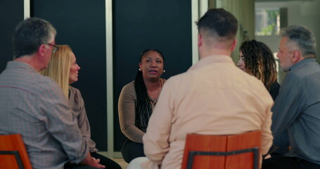 Support group gathered in circle as woman opens up, participants listening attentively in moment of...