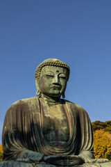 Great Buddha of Kamakura against a clear blue sky, capturing the serene expression of the iconic Daibutsu statue

