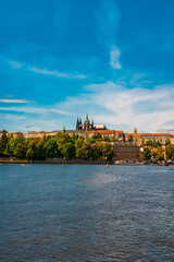 Obraz premium Prague Castle and St. Vitus Cathedral dominating Vltava river.