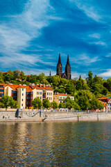 Obraz premium Vysehrad Basilica and colorful buildings along Vltava embankment.