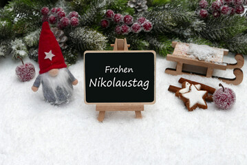 Grüße zum Nikolaustag auf einer Schiefertafel mit Süßigkeiten und Keksen. Frohen schönen...