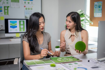 Women discussing sustainability and green business strategies in office