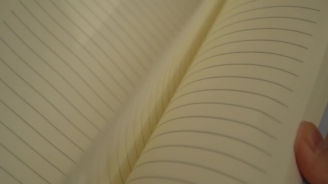 Slow motion of a woman's hand leafing through a blank notepad at her workplace in the office. Lack of business ideas and meetings