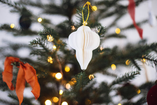 Stylish bows and baubles on Christmas tree branches close up. Modern ornaments on decorated xmas tree with lights. Winter holiday banner, atmospheric christmas time. Merry Christmas! - Powered by Adobe