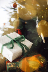 Stylish Christmas presents. Merry Christmas and Happy Holidays! Wrapped Christmas gift boxes against xmas tree with lights bokeh. Holiday banner, atmospheric winter time