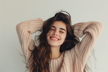 a woman with long hair smiling and holding her hands up