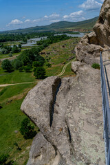 Rock ledge with lizard overlooking river valley and distant hills