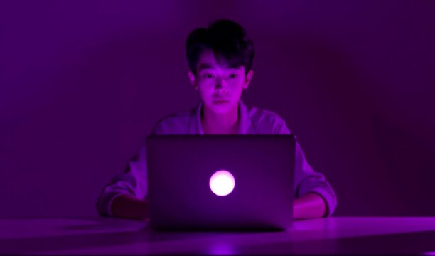 Young man illuminated by blue light working on a laptop at a white surface 4k and hd  video