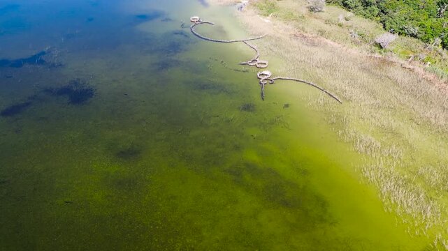 Traditional Thonga or Tsonga Fish traps on the edge of Kosi Lake at Kosi Bay, camera slowly panning up along the lakeshore, showing the fish traps 4K Aerial Video