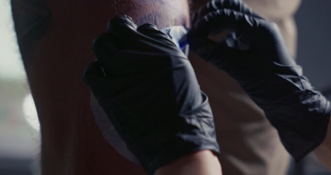 Fresh tattoo stencil of a sun with a face applied to a man's leg, ready for the tattooing process.