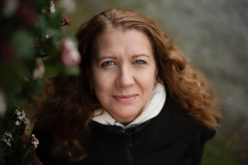 Beautiful middle-aged woman with beautiful eyes looking up with hope and smile, woman relaxed after walking and meditating in park, depression gone