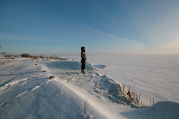 A beautiful winter landscape with a blue sky, snowy expanses, and a village on the horizon. Winter is in full swing.