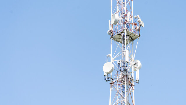 Communication tower or mobile phone tower with a 5G cellular network. The concept of a global connection and internet network in the context of a city. High quality photo