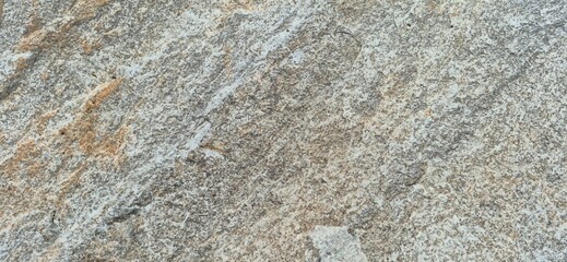 Close up of a natural stone texture, revealing rugged surface and abstract patterns. Background for construction, natural material and geology concept.