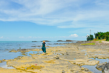 One Asian woman enjoying the beautiful volcanic rock landform coastline landscape of Leigong Island...