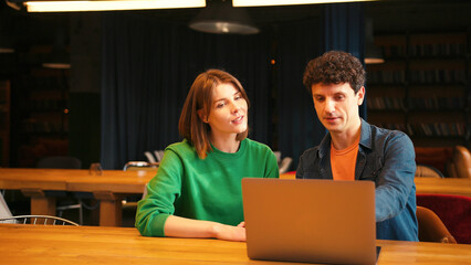 Colleagues, smiling woman and man having video conference meeting on laptop in modern office