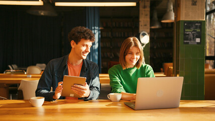 Young students collaborating on project in university library colleagues working in modern coworking