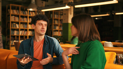 Young students collaborating on project in university library colleagues working in modern coworking