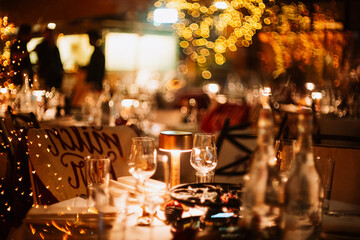 Set, empty, festive dinner table with bokeh lights. Moody, romantic atmosphere, very shallow depth of field, no people