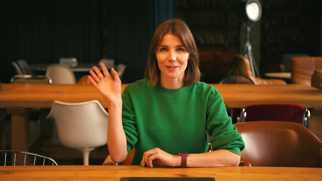 Cheerful beautiful woman joining video conference call on laptop in modern office - Powered by Adobe