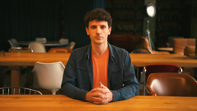 Professional man gesturing and talking during video call in a modern office