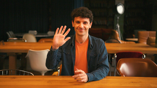 Professional man gesturing and talking during video call in a modern office