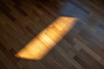Sunlight spot or beam on a parquet, or hardwood tile floor inside apartment room. Top down view, no...