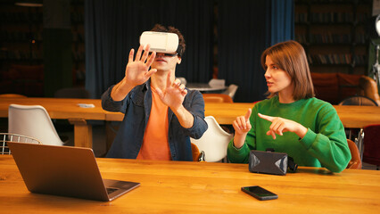 Man exploring virtual reality with woman assistant, online technology concept