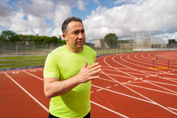 Mature man jogging on running track, maintaining healthy lifestyle