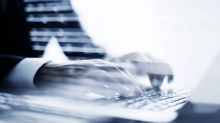 A business professional typing on a keyboard in a blurred corporate environment, representing productivity, decision making and focused digital workflow in a modern workspace.
