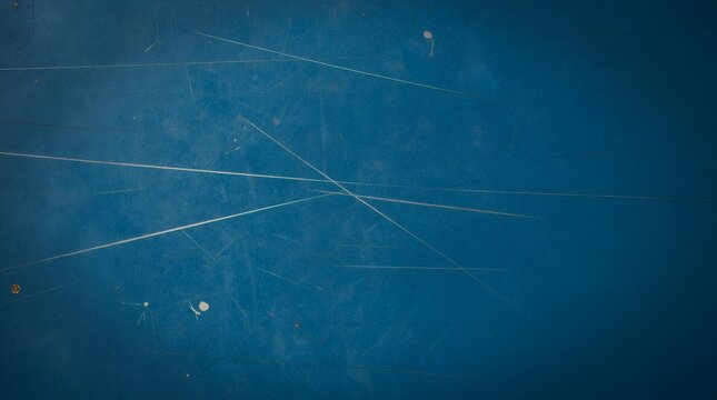 Close up of scratched textured blue surface with worn marks and small distressed spots